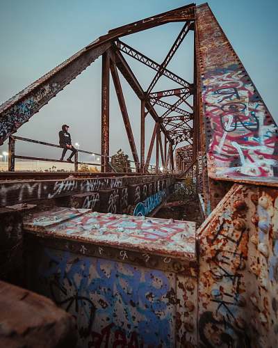 23516 magic mountain pkwy man sitting on brown metal bridge santa clarita